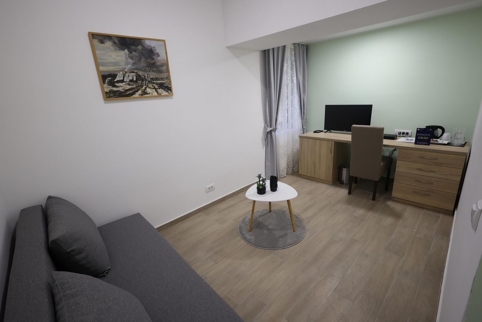 Dnevni boravak apartmana sa garniturom i radnim stolom