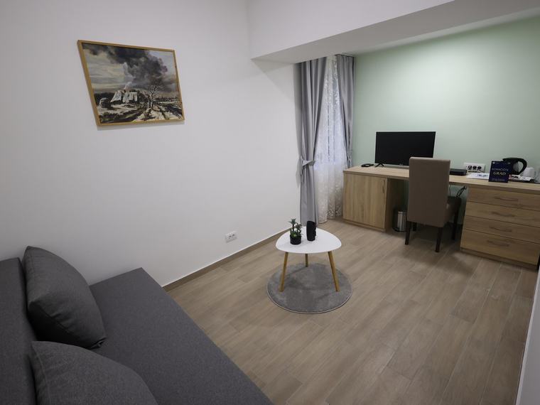 Dnevni boravak apartmana sa garniturom i radnim stolom